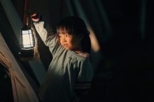 Small girl holding out a lantern to represent recovery from childhood trauma effects shown in the ACE study