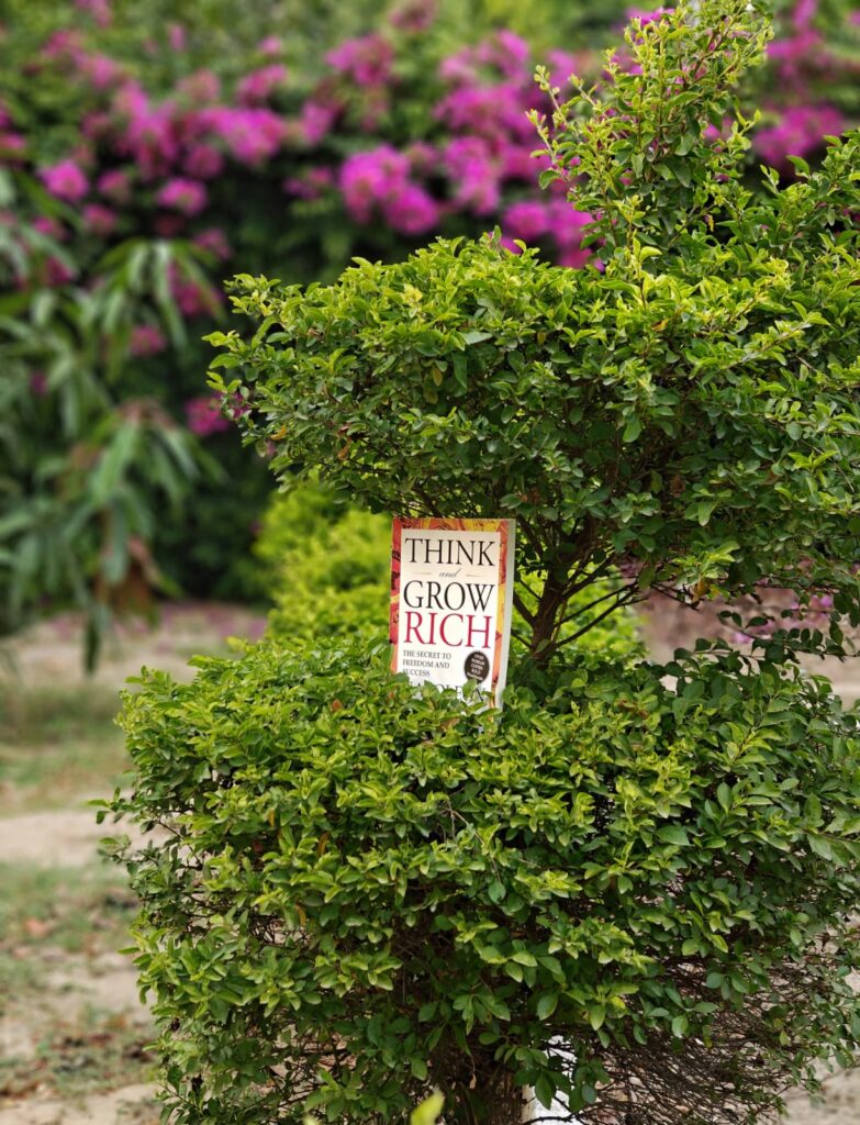 "Think and Grow Rich" book in a garden.
